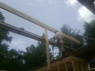 Carpenter setting a ridge beam over a new addition frame — Ice Dam Removal by Roofing Brothers in Guatay