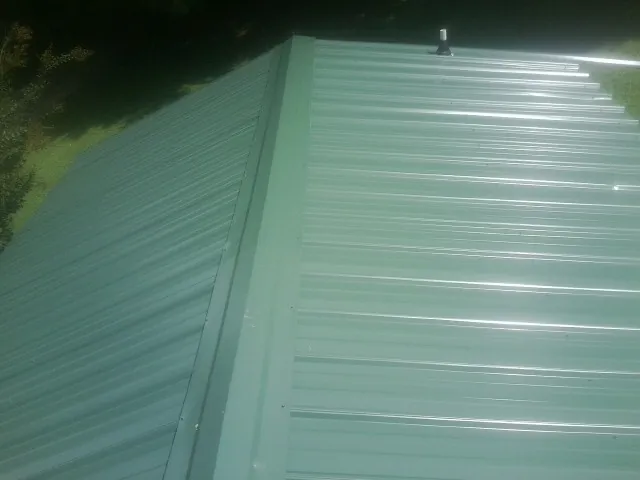 New green metal panels meeting at the ridge of a roof — Flat Roof Repair work by our crew in Guatay